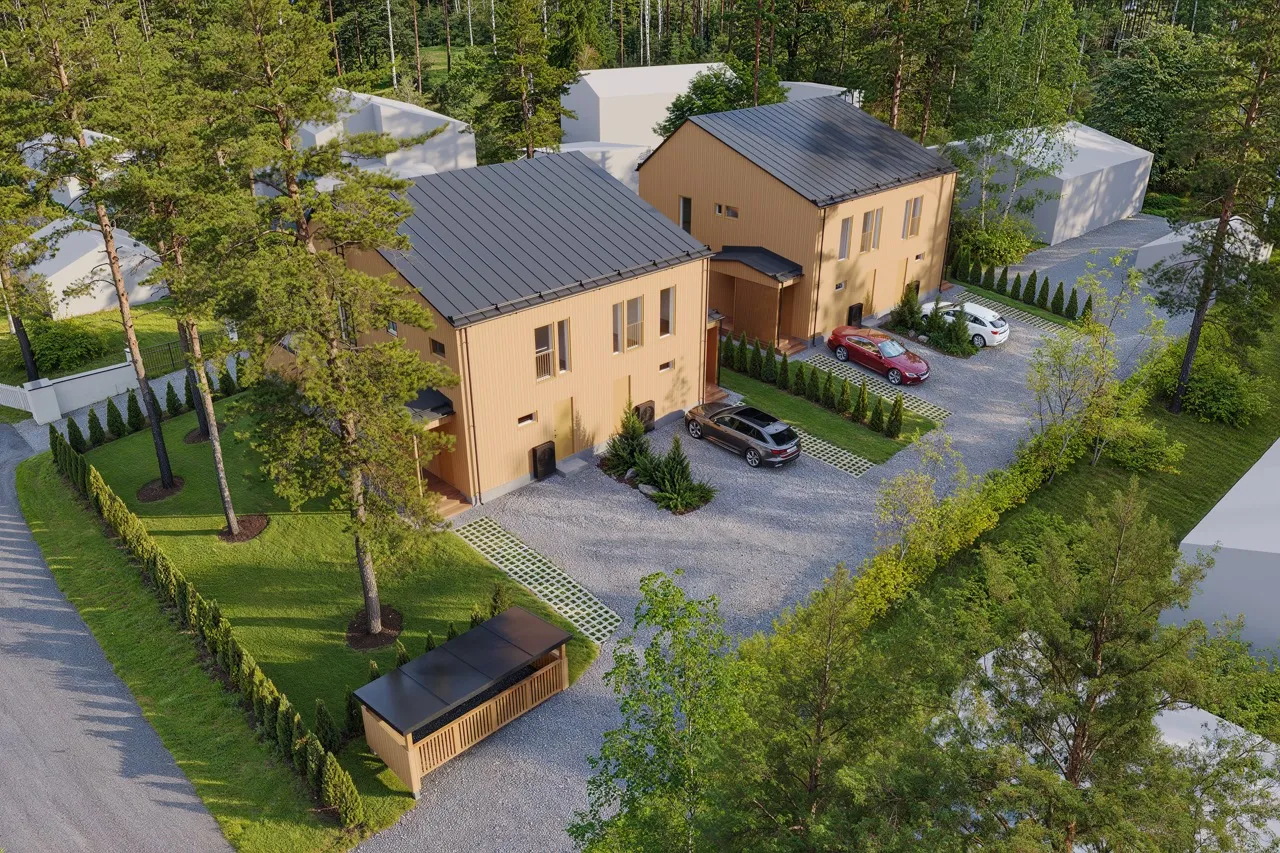 Ilmakuva kahdesta modernista puutalosta, joiden selkeälinjainen arkkitehtuuri erottuu vihreiden pihojen ja sorateiden keskellä.